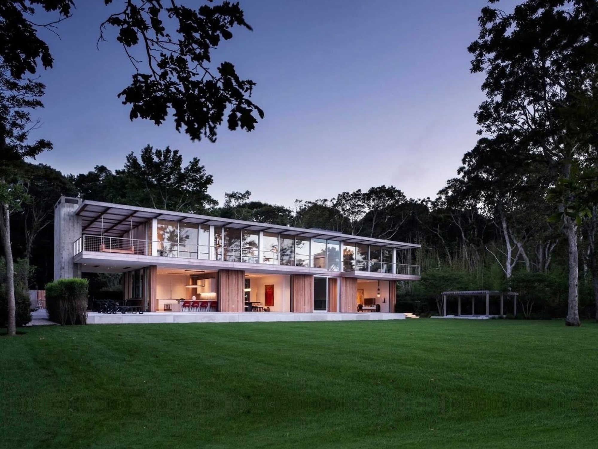 Modern glass residence and lawn at dusk